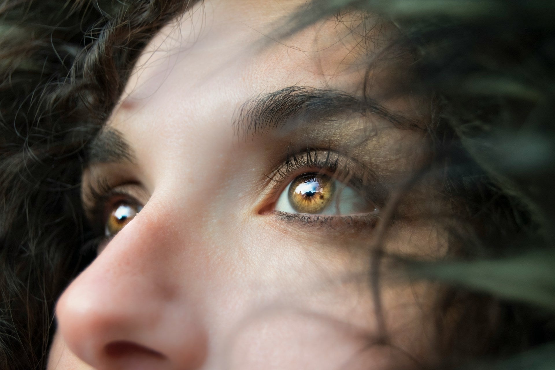 close up of womans face brown eyes looking in distance